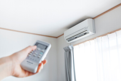 climatiseur au dessus d'une fenêtre avec une télécommande