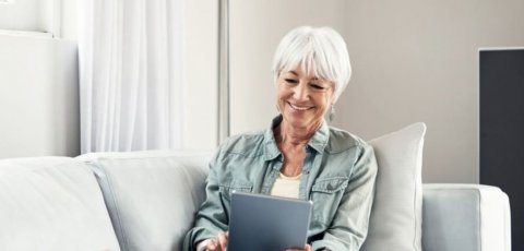 Utilisateur avec une tablette sur un canapé