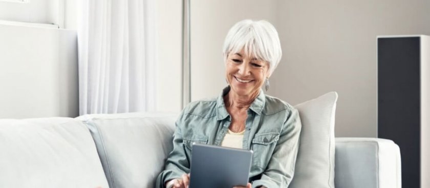 Utilisateur avec une tablette sur un canapé