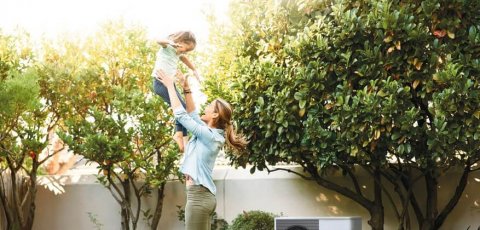 Pompe à chaleur dans un jardin avec une famille en train de jouer