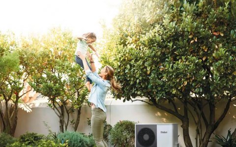 Pompe à chaleur dans un jardin avec une famille en train de jouer