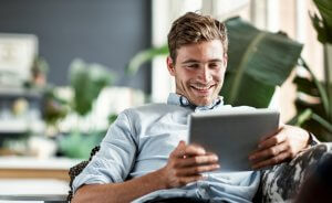 Homme utilisant tablette pour comparer entreprises RGE