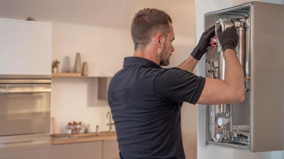 Technicien bricolant une chaudière