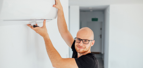 Homme installant une climatisation