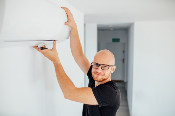 Homme installant une climatisation