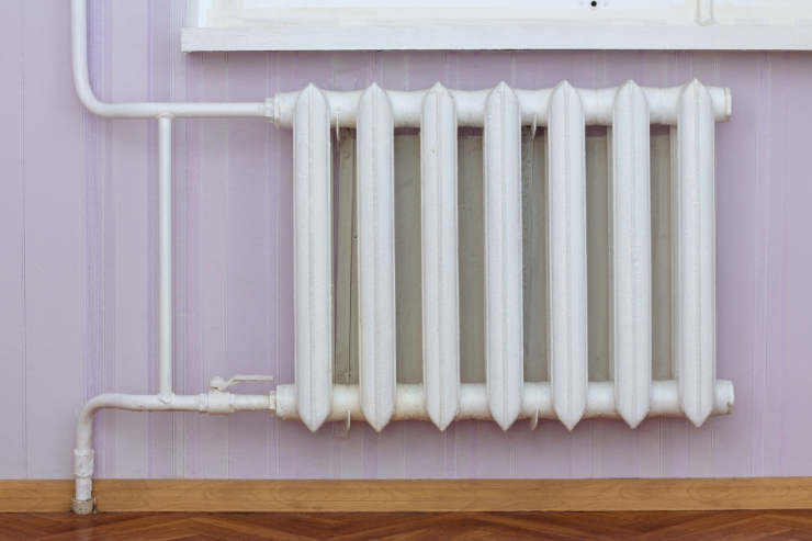 petit radiateur en fonte sous une fenêtre