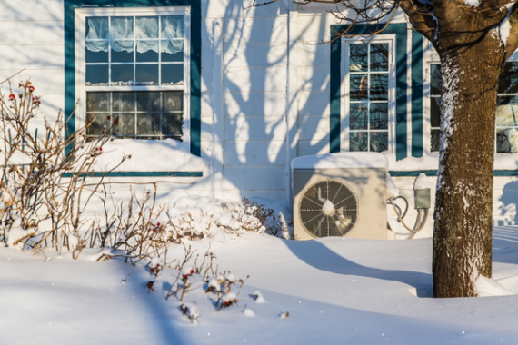 jardin en hiver avec unite exterieure pompe a chaleur devant maison