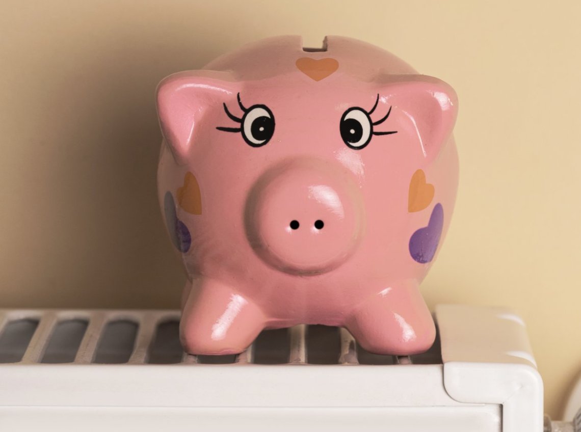 Piggy bank sits on a radiator cochon rose sur radiateur