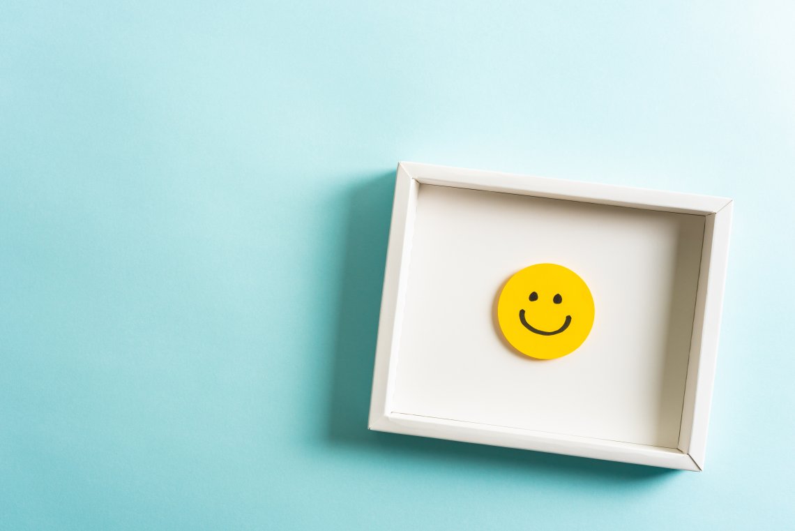 smiley jaune dans un cadre blanc et un arrière plan bleu