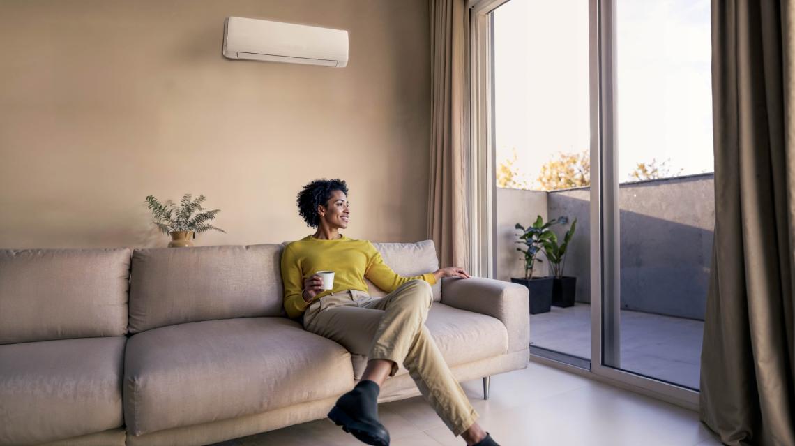 Femme sur son canapé sous la climatisation