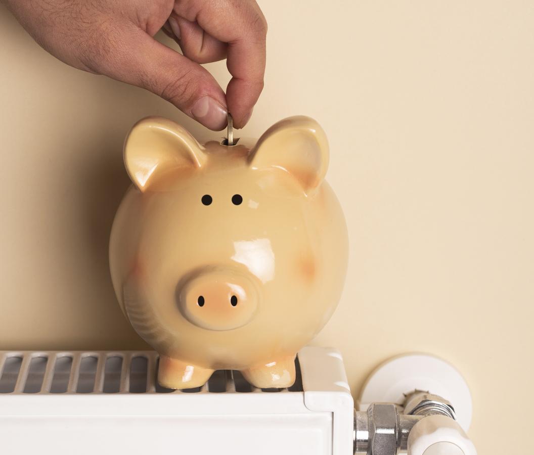 Tirelire cochon sur un radiateur - faire des économies en chauffage