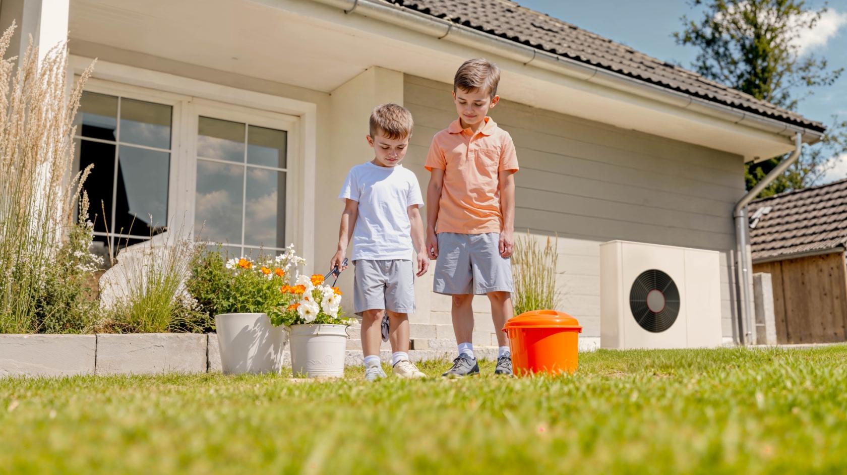enfants devant une pompe à chaleur dans le jardin